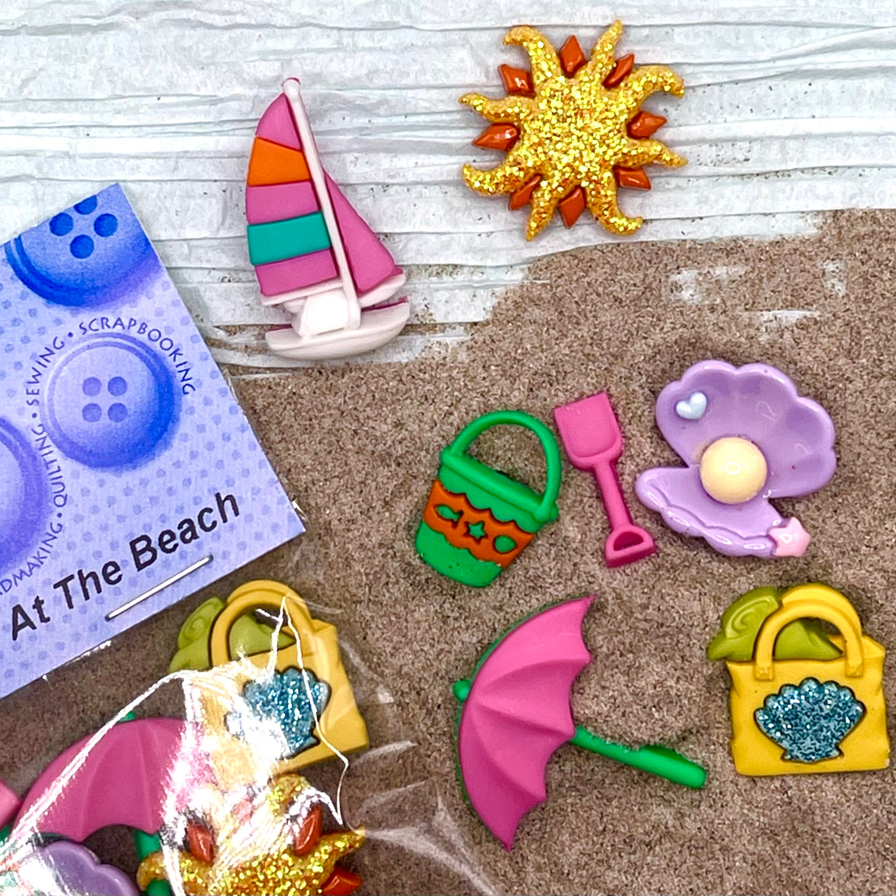 6 shank-back button embellishments pack with colorful beach items, sailboat, glitter sun, pearl clam, sand bucket and shovel, beach umbrella