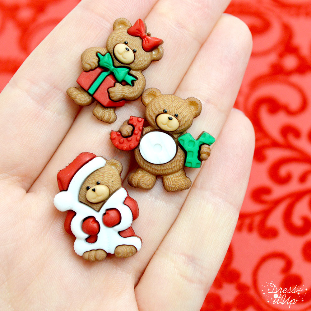 A hand holding our 3 bear Christmas-themed button pack